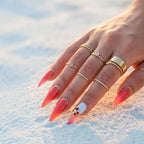 Press to Impress Saint Lucia press-on nails with coral-red gel, gold accents, and a crystal-embellished white nail.