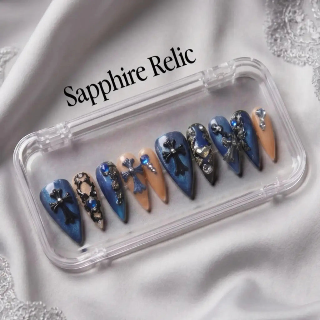 Press to Impress Saphire Relic stiletto press-on nails in blue, nude, with cross designs and rhinestones.