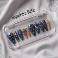 Press to Impress Saphire Relic stiletto press-on nails in blue, nude, with cross designs and rhinestones.
