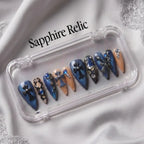 Press to Impress Saphire Relic stiletto press-on nails in blue, nude, with cross designs and rhinestones.