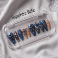 Press to Impress Saphire Relic stiletto press-on nails in blue, nude, with cross designs and rhinestones.
