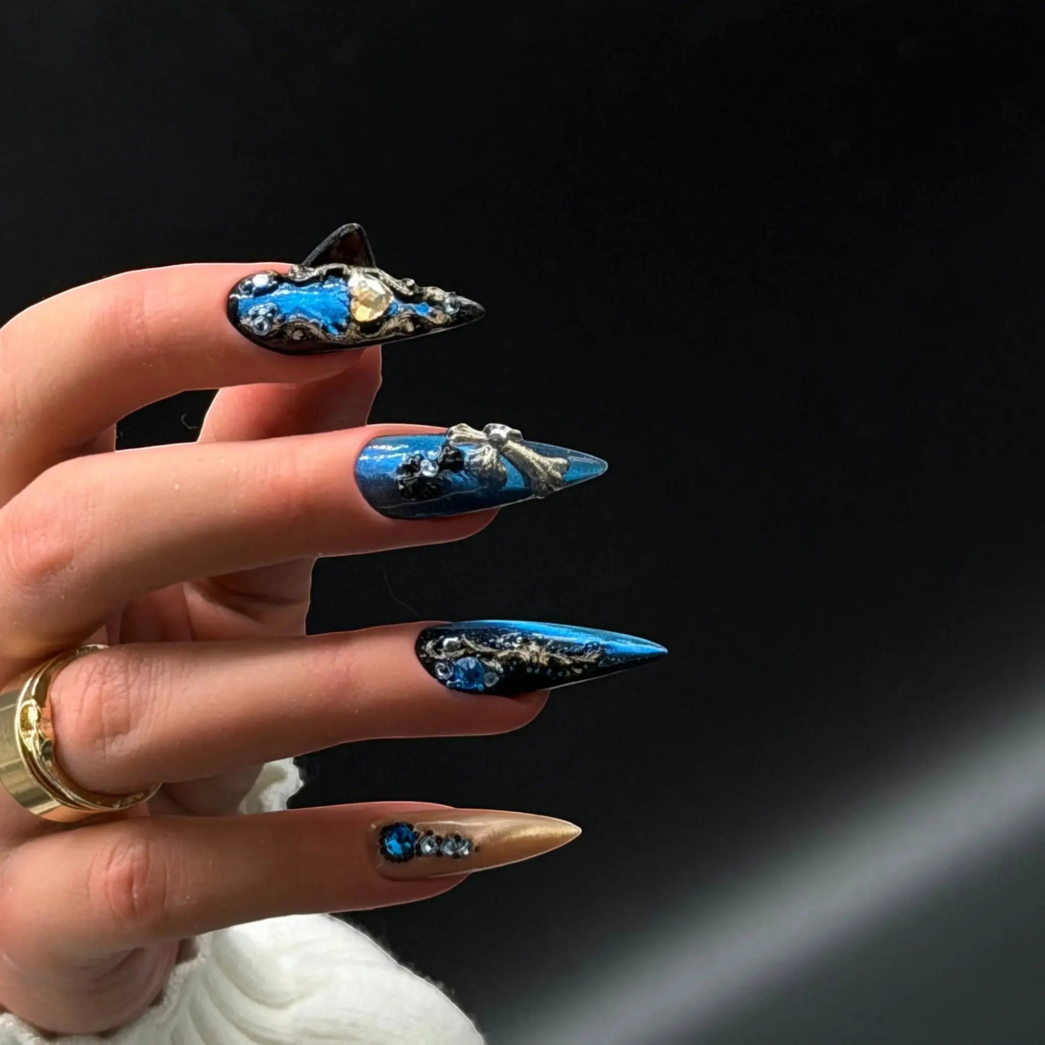 Press to Impress Saphire Relic stiletto press-on nails in blue, gold, and nude with rhinestones and 3D embellishments.