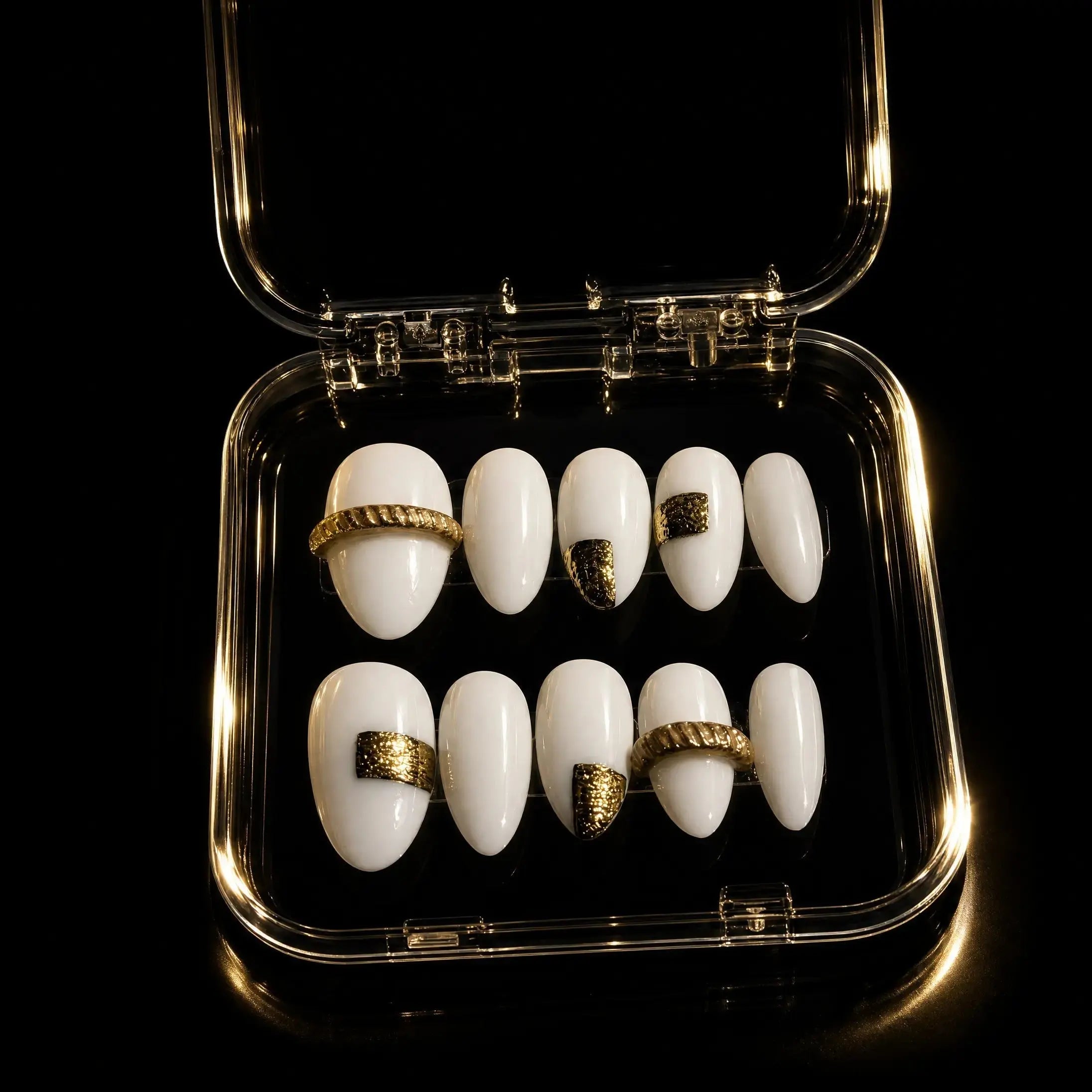 Press to Impress Gold Muse almond-shaped press-on nails in milky white with gold accents and textured gold bands.