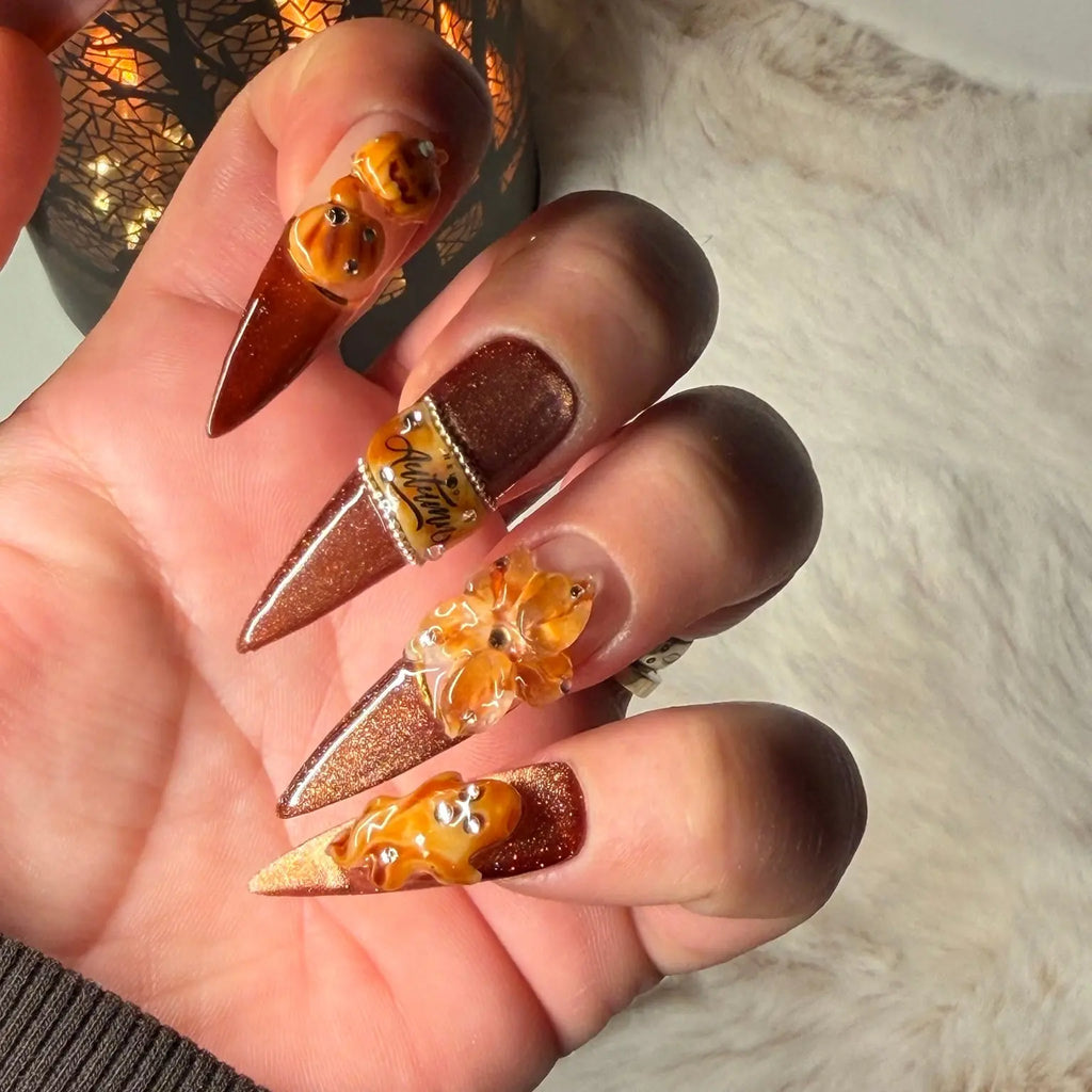 Pumpkin Hour Halloween press-on nails worn on hand with copper glitter and raised autumn decorations