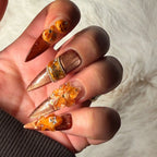 Pumpkin Hour stiletto nails showing raised pumpkins, translucent amber flower and copper shimmer